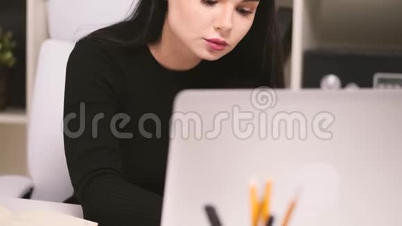办公室里的女商人在她的笔记本上打字视频的预览图