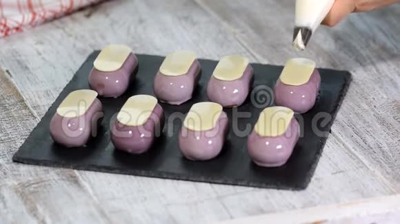 糖果店在厨房用鲜奶油装饰小蛋糕视频的预览图