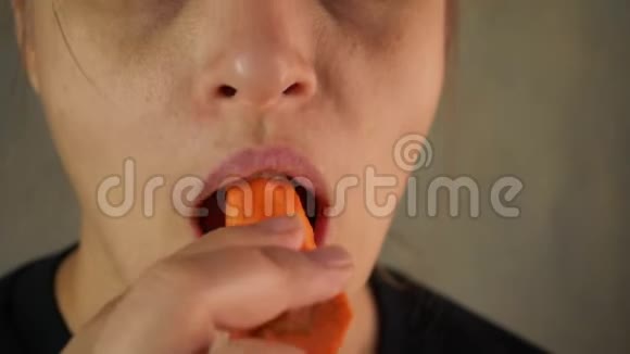 年轻女子吃生胡萝卜以增强视力丰满的嘴唇特写视频的预览图