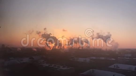一家炼油厂烟囱的时间推移浓烟滚滚背景是粉红色和黄色的日落视频的预览图