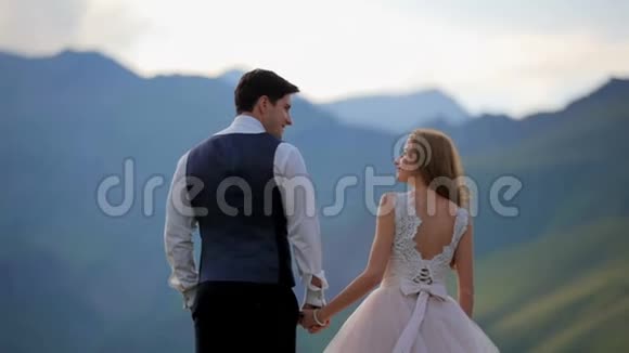 幸福的女孩和男孩带着温柔和爱在晚上在山里互相看着卡兹贝克格鲁吉亚视频的预览图