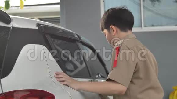 亚洲男孩穿着童子军制服在家洗车泰国男孩童子军在家帮助你的家人视频的预览图