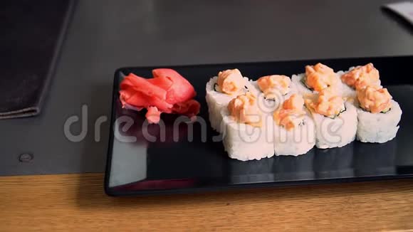 亚洲美食寿司在餐厅的黑色盘子滑块观看慢速视频的预览图