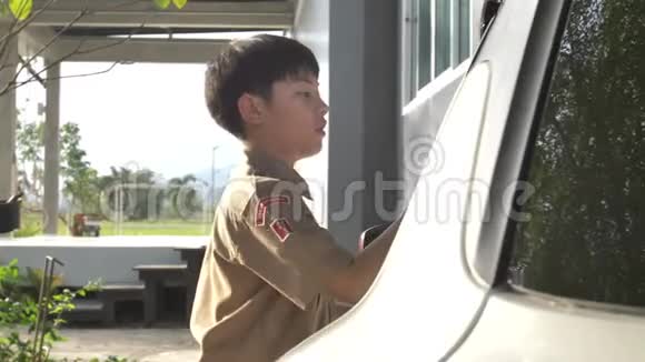 亚洲男孩穿着童子军制服在家洗车泰国男孩童子军在家帮助你的家人视频的预览图