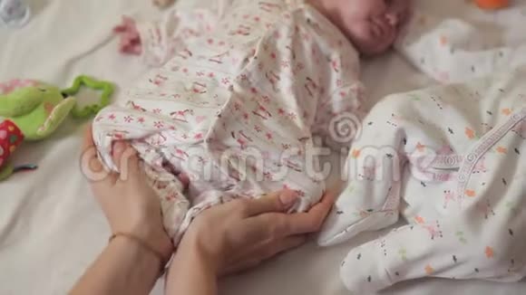 新生儿躺在他的背上他的母亲按摩他的腿新生儿理疗视频的预览图