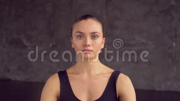 一位20多岁的女性坐在瑜伽工作室特写镜头里的莲花位置上呼吸视频的预览图