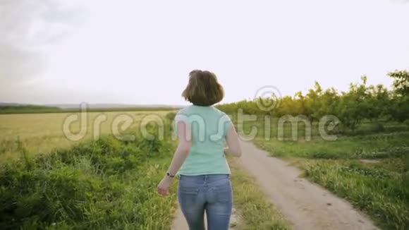 西班牙农村麦田小路上享受生活跑步的年轻白种女青年视频的预览图