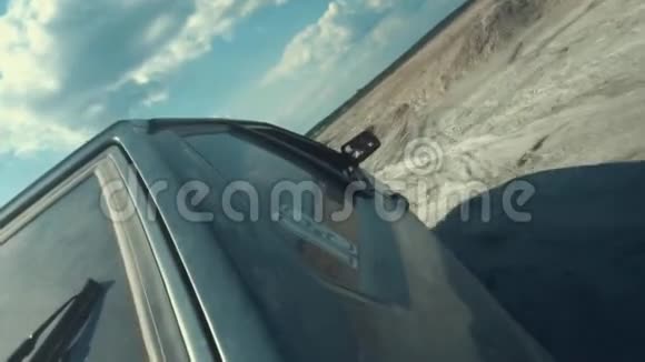 从黑色俄罗斯轿车侧面近距离观看后车窗上有13个数字在沙质表面与蓝色相对移动视频的预览图