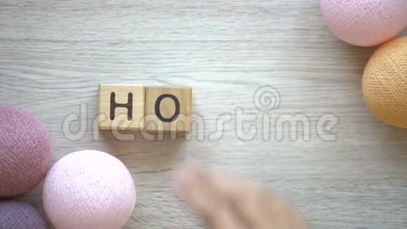 爱好女人做木头方块的字五颜六色的线球躺在桌子上视频的预览图