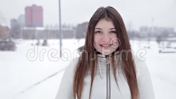 年轻开朗的女孩在公园的冬天散步在雪地里玩耍寒冷视频的预览图