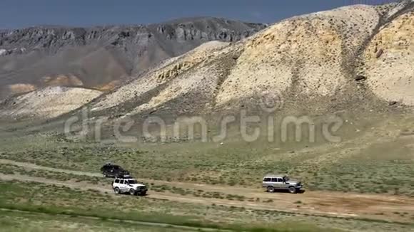 沙迹路上狩猎车辆行驶的景观在4x4路附近沿砾石小径行驶视频的预览图