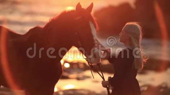 在岩石海岸骑着马的女人爱和友谊的概念视频的预览图