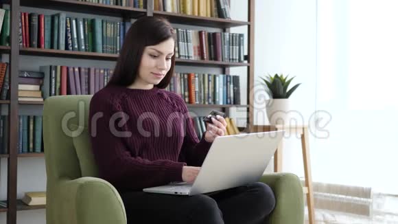 网上购物的女人坐在沙发上视频的预览图