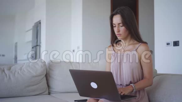 年轻女子在灯光下的别墅里用画纸做电脑视频的预览图