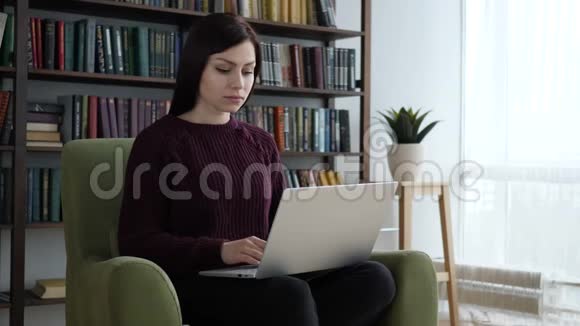 休闲坐着的女士关闭笔记本电脑和离开沙发在办公室视频的预览图