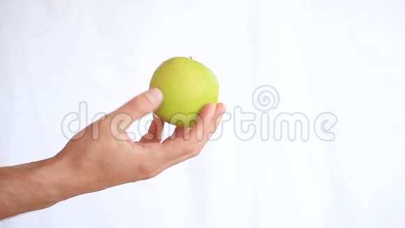 男人白色背景上的手拿着水果绿苹果视频的预览图