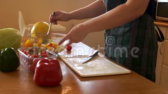 特写女手正在碗里拌蔬菜沙拉女孩用勺子尝一尝沙拉家庭主妇准备视频的预览图