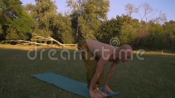 在城市公园的一片草地上用一个裸露的浅褐色做瑜伽体式视频的预览图