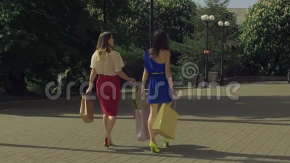在城市大街上散步的快乐购物妇女视频的预览图