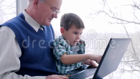在网上支付爷爷手里拿着信用卡通过电脑上网购物视频的预览图