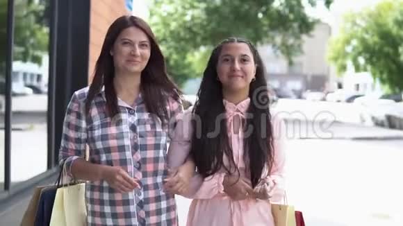 两个女孩在购物中心附近购物手里拿着包裹购物态度很好慢慢慢慢视频的预览图