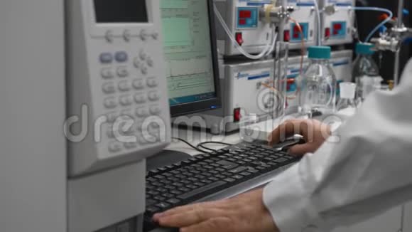 穿着无菌白色西装的科学家在化学实验室的电脑上工作视频的预览图