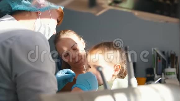 在牙医接待的女孩口腔医生检查了孩子牙齿淘气的女孩微笑着视频的预览图