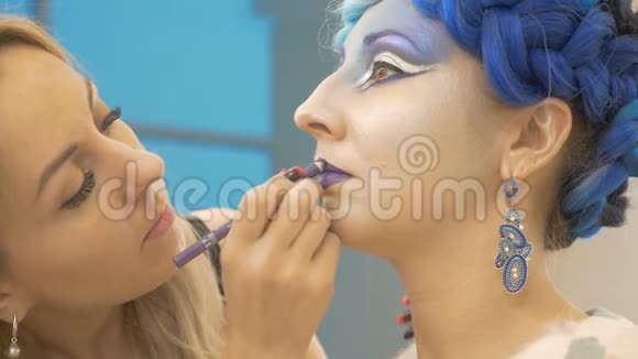化妆师用紫色画出模特嘴唇创造出神奇的形象准备艺术摄影视频的预览图