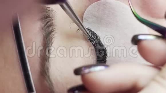 美容师为美丽的女孩增加睫毛睫毛延伸手术特写视频的预览图