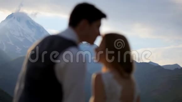 幸福的女孩和男孩带着温柔和爱在晚上在山里互相看着卡兹贝克格鲁吉亚视频的预览图