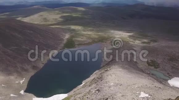 从石质山的山顶下降到几个有雪和青草的湖泊那里没有一个人视频的预览图