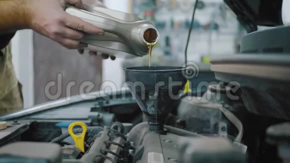 汽车维修技工向汽车发动机注入新的油润滑剂注入新的清洁合成油视频的预览图