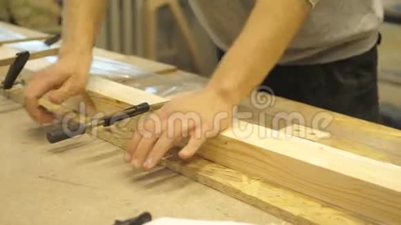 木工车间的工匠用金属夹子夹住木板视频的预览图