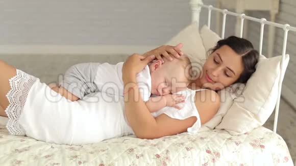 温柔体贴的母亲把熟睡的新生儿抱在怀里视频的预览图
