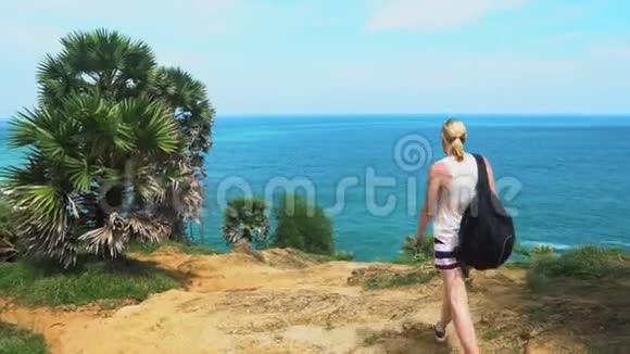 女孩游客在亚洲旅游带背包来到热带森林里面有棕榈树和海景视频的预览图