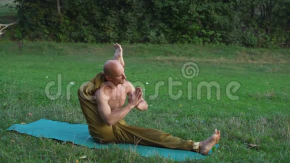 秃顶瑜伽与裸托练习阿萨纳瑜伽表演练习在城市公园视频的预览图