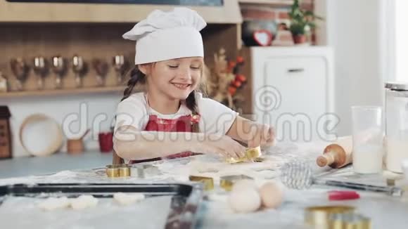 可爱的小女孩用生面团做饼干以鲜花和星星的形式带着妈妈的小女儿视频的预览图