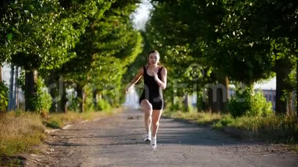 在绿色公园奔跑的年轻运动员视频的预览图