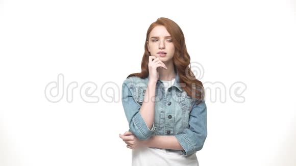 开朗的女孩在灰色背景下思考一个穿着牛仔布穿着灰色衣服的休闲快乐的女人的肖像视频的预览图