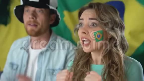 巴西球迷在电视上观看足球赛庆祝球队胜利视频的预览图
