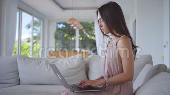 年轻女子在灯光下的别墅里用画纸做电脑视频的预览图