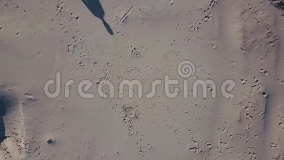 空中射击三个男人在沙漠中汇合太阳在沙滩上投下阴影顶部视图视频的预览图