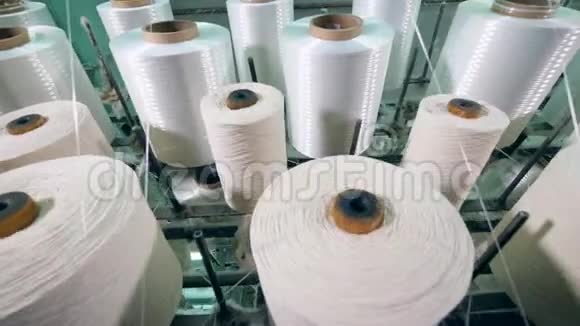 纺织厂纺纱机上的纱线线轴视频的预览图