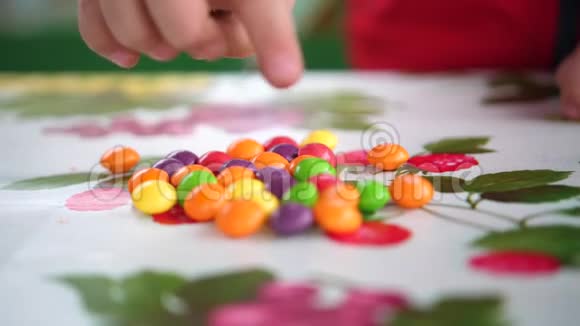 小小的彩色糖果孩子们的手从桌子上拿糖果双手合拢视频的预览图