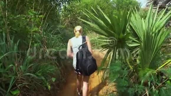 女孩游客在亚洲旅游带背包来到热带森林里面有棕榈树和海景视频的预览图