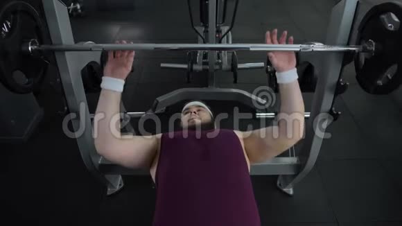 胖乎乎的男人在体育运动中无法举起沉重的杠铃身体健康视频的预览图