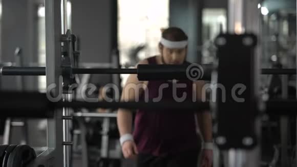 肥胖男子几乎不用杠铃在健身房锻炼健身锻炼运动视频的预览图