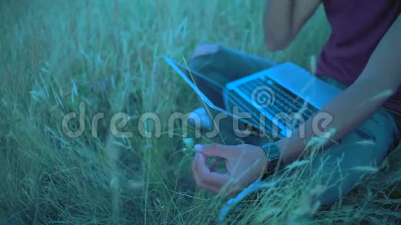 特写镜头一个印度男人的手在草地上坐着一个的电话交谈中打开了一个被撕裂的纸刃视频的预览图