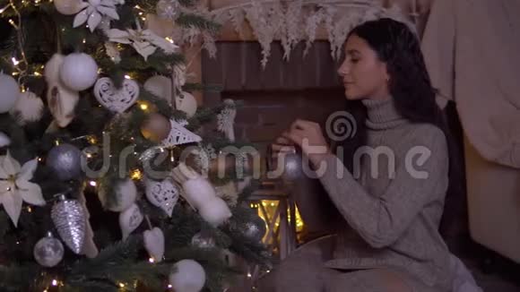 一个女孩装饰一棵圣诞树一个漂亮的球心情很好高清高清视频的预览图