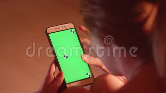 女孩滚动智能手机与绿色屏幕和三维跟踪点视频的预览图